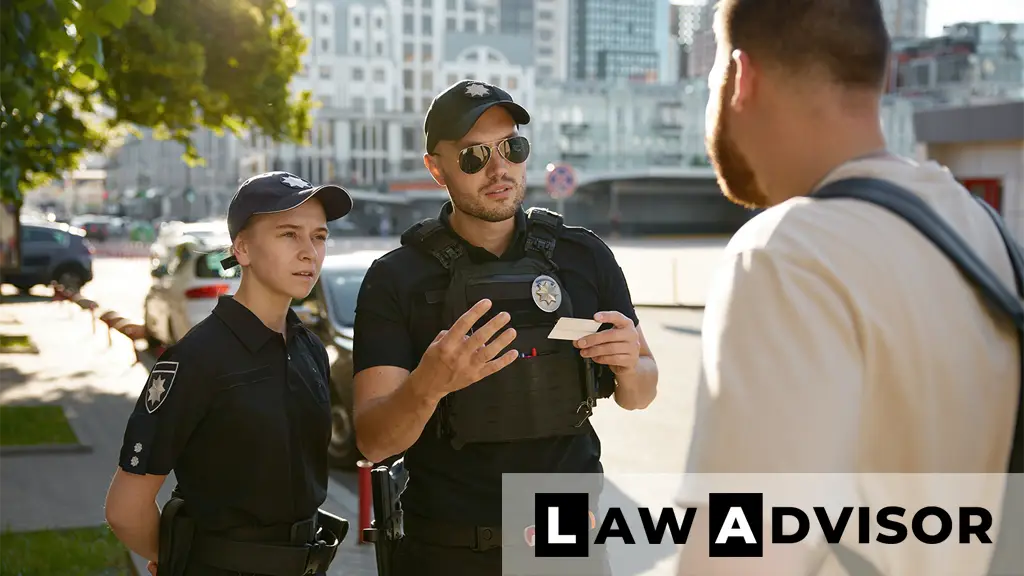 Police officer and policewoman checking ID during roadside stop, representing law enforcement questioning procedures.