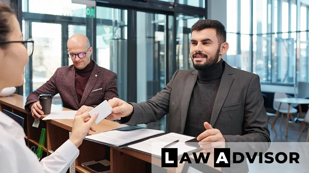 Smiling young businessman holding a business license card