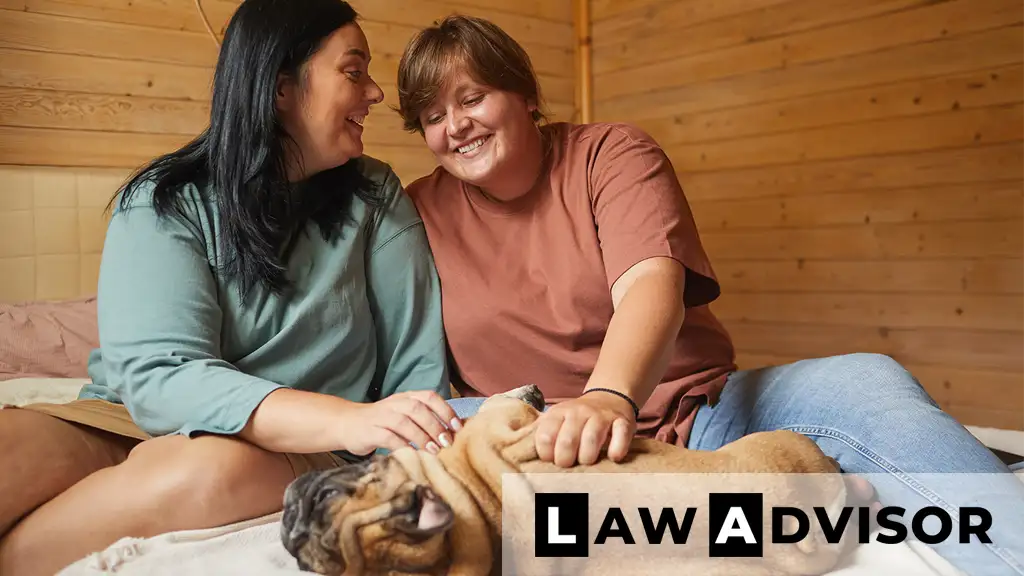 Smiling pet owners holding their dog outdoors
